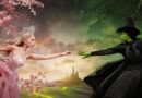 Glinda and Elphaba reach for each other (promotional image for Wicked Part 1)