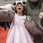 a Porg cries out in front of a giant Sock Monkey Cute Porg Costume - Star Wars at C2E2 2018